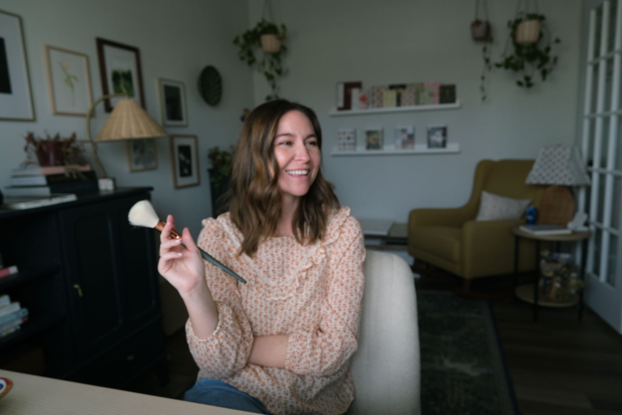 Pen+Pillar artist smiling and holding a paintbrush in her studio