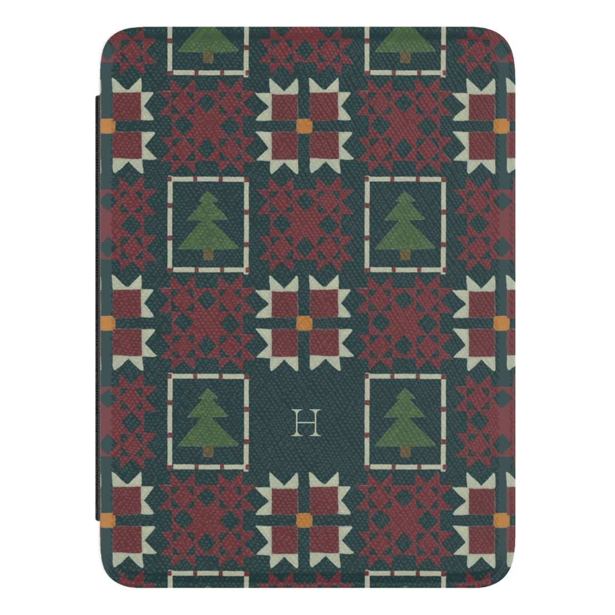 Evergreen Personalized Kindle case, close-up of the front: deep green quilt blocks with red stars and small pine trees with the initial H