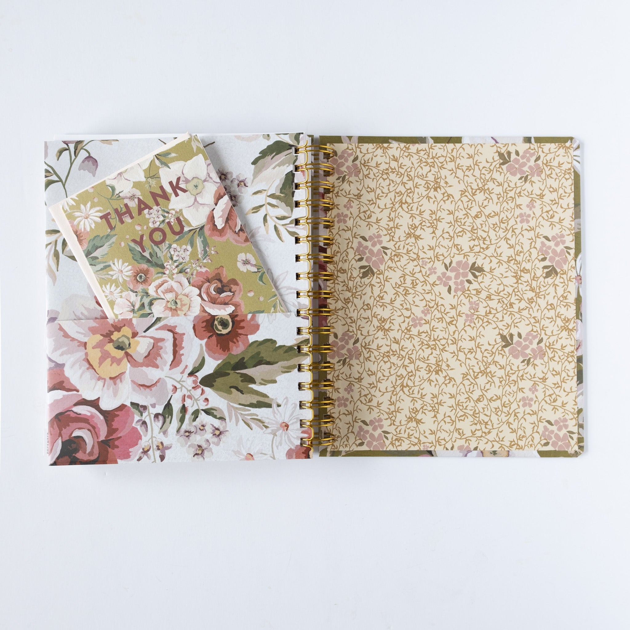 2026 Meadow weekly planner with floral cover and gold spiral binding, featuring a thank you card inside.