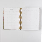 2026 Meadow Weekly Planner opened to January 2026, featuring blank monthly calendar pages and gold spiral binding.