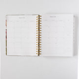 2026 Meadow Weekly Planner opened to January 2026, featuring blank monthly calendar pages and gold spiral binding.