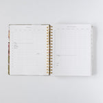 2026 planner bundle open to a weekly layout with gold spiral binding and floral cover design.