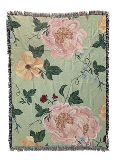 Floral patterned throw blanket with pink and orange flowers on a green background