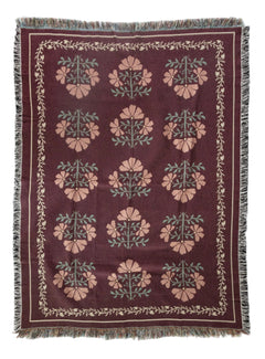 Decorative throw blanket with floral pattern on a white background