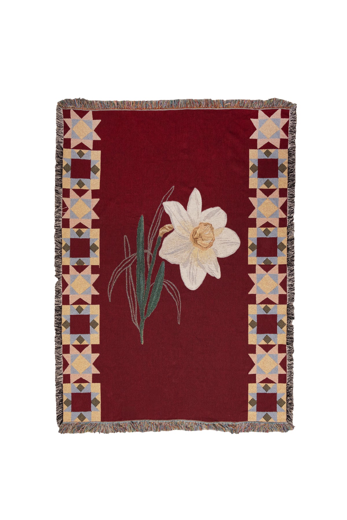 Red woven blanket with a white narcissus flower and geometric star borders in tan, blue, and yellow.
