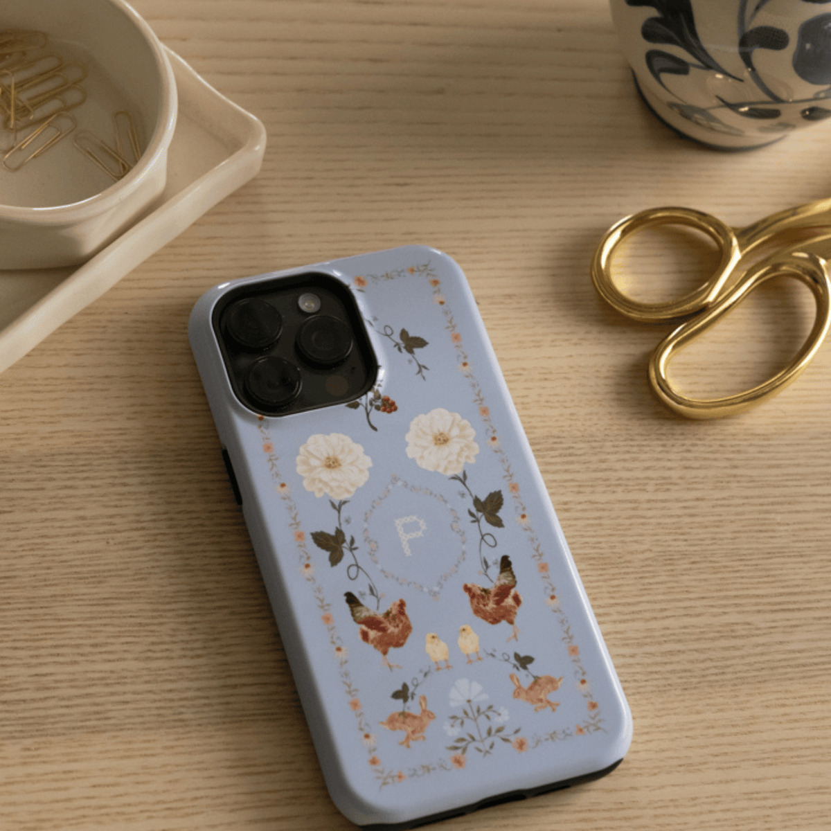 Farmland Personalized iPhone case with the initial P on a wooden desk beside gold scissors