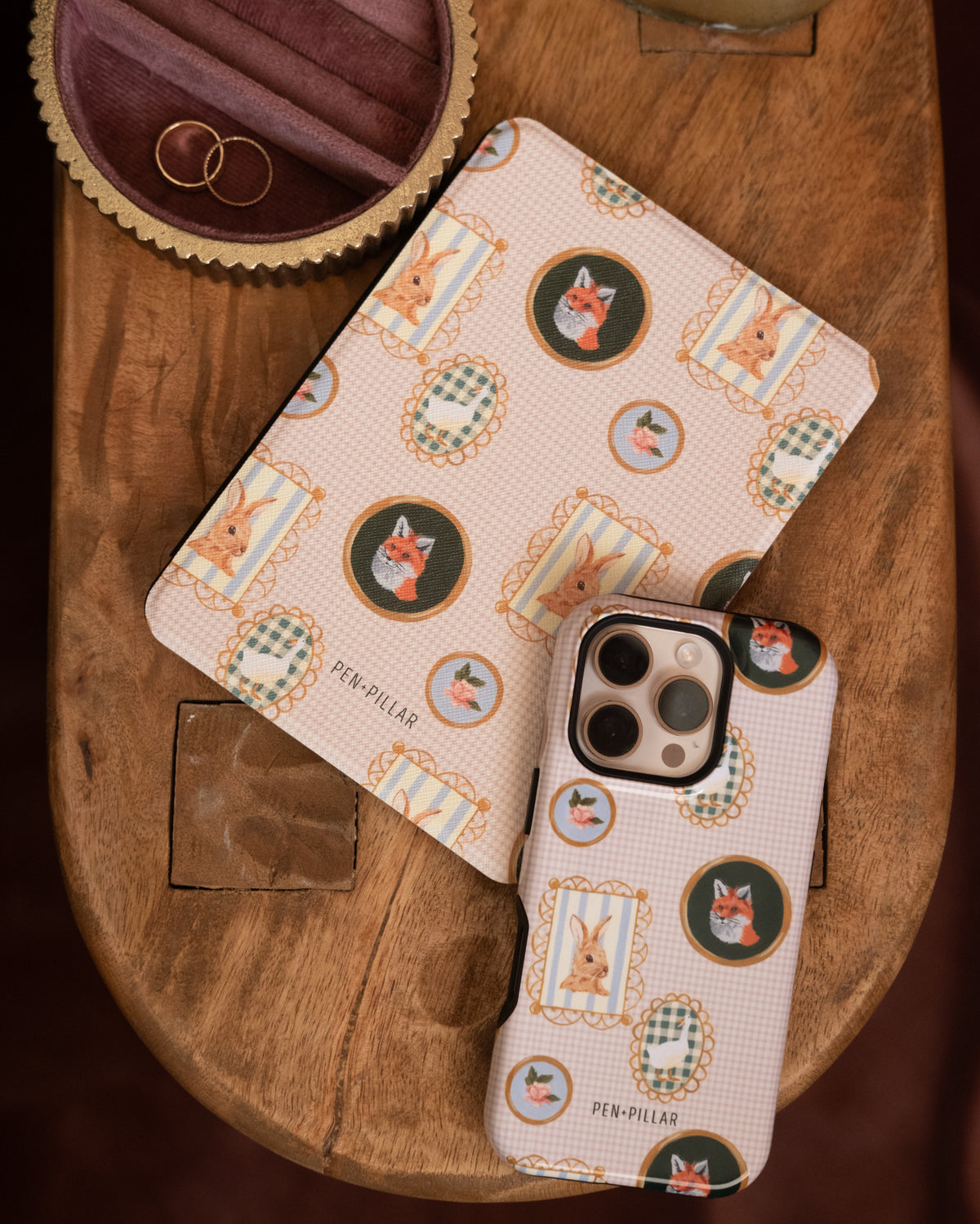 Menagerie Kindle case and iPhone case on a wooden table