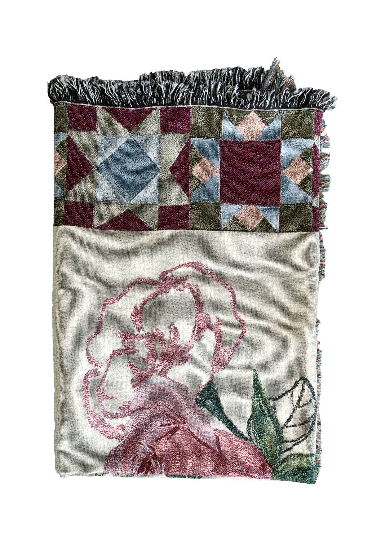 Folded cream woven fabric blanket with a pink rose illustration, geometric star patterns, and a fringed edge.