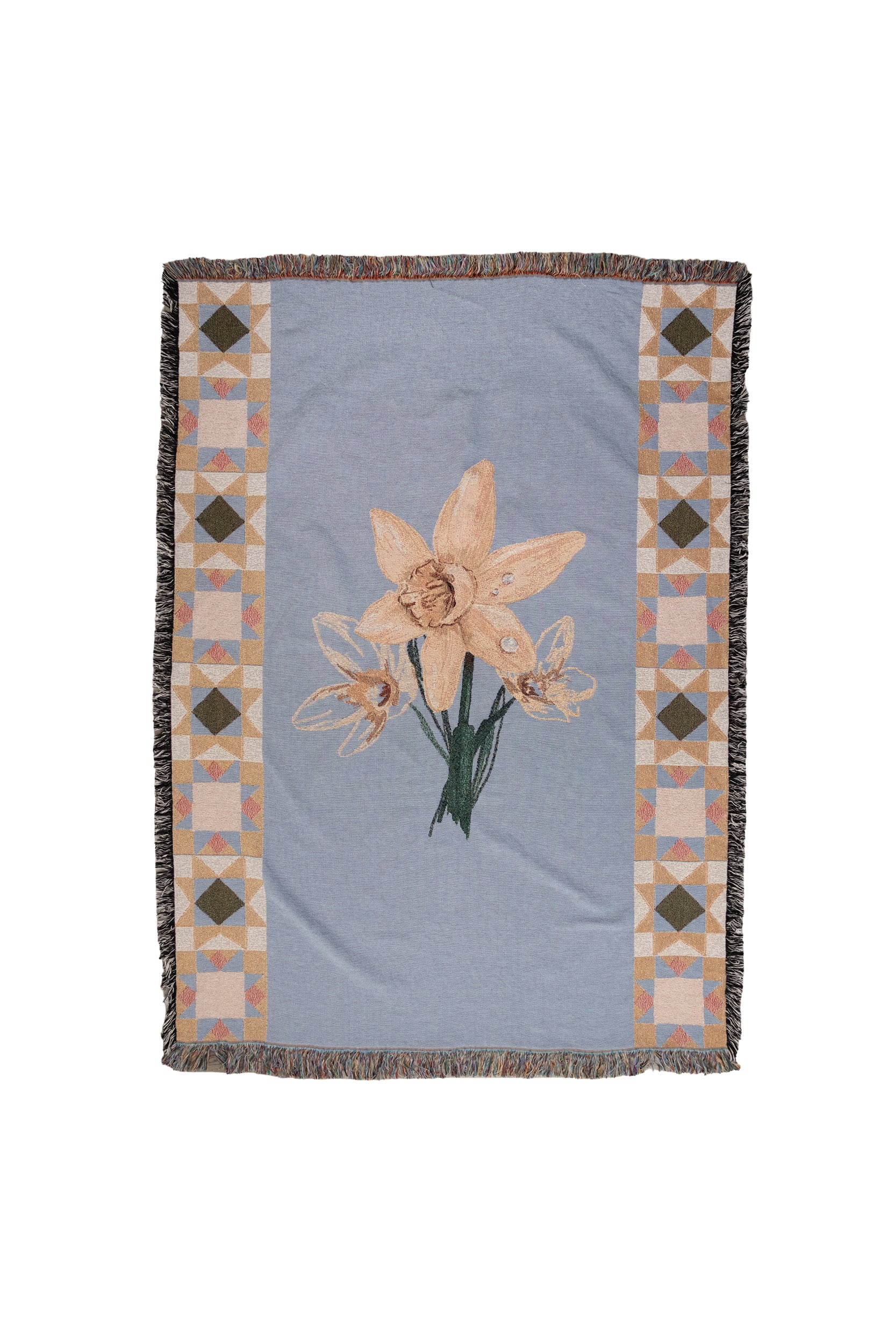 Blue woven fabric blanket with fringed edges, featuring a central daffodil design and geometric patterned borders.
