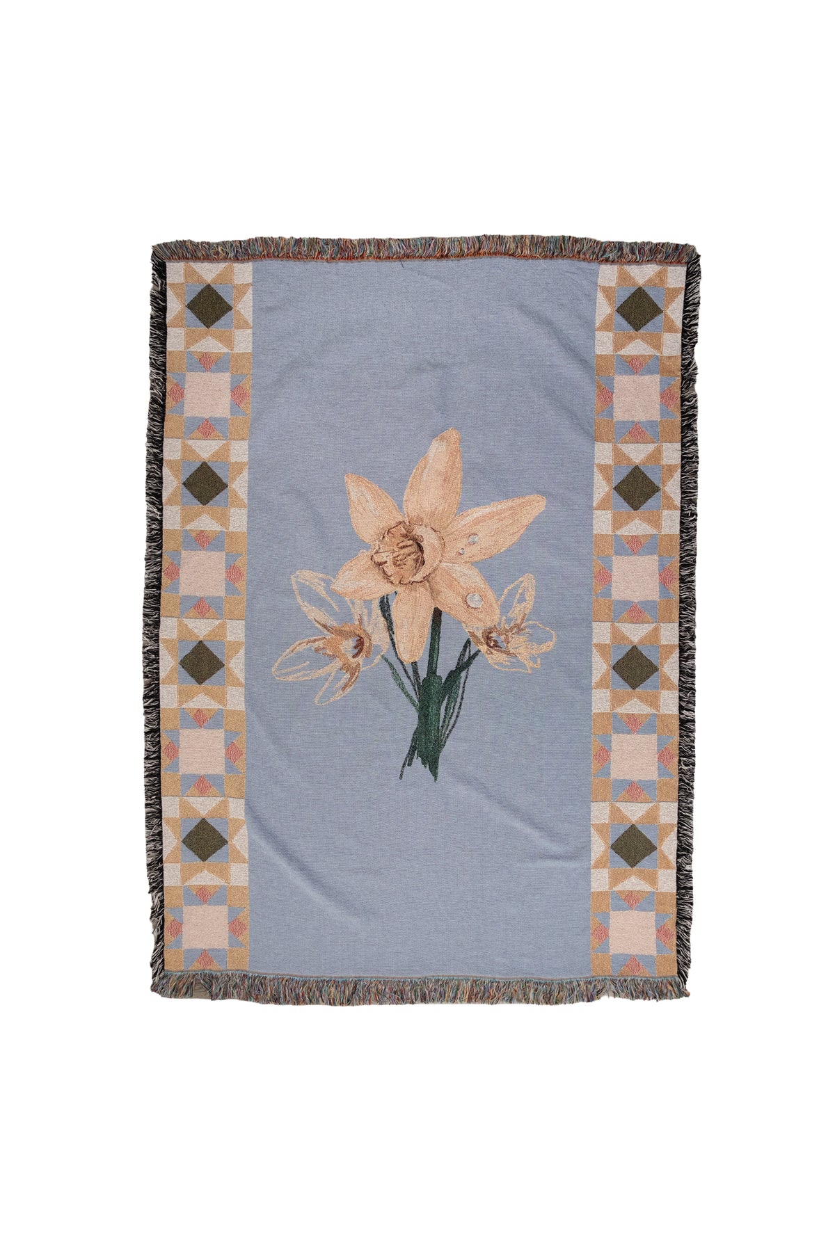 Blue woven fabric blanket with fringed edges, featuring a central daffodil design and geometric patterned borders.
