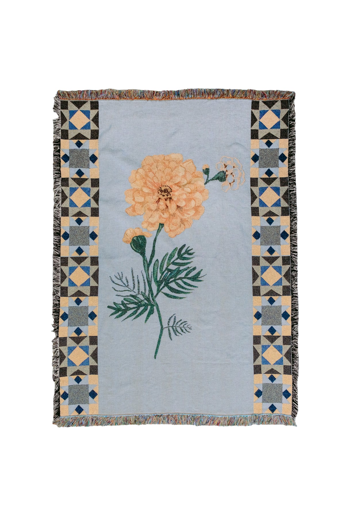 Light blue woven fabric blanket with a central orange marigold flower and geometric patterned borders.