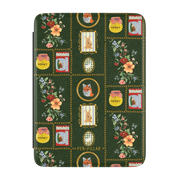 Sampler Kindle case, front cover: cross-stitch style squares of jars, animals and florals on deep green