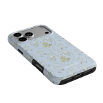 Artichoke iPhone case featuring a light blue floral design with artichokes and small flowers, angled view showing buttons ...