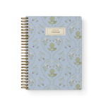 Artichoke notebook with a light blue floral design and gold spiral binding, featuring a label that reads "Notebook.