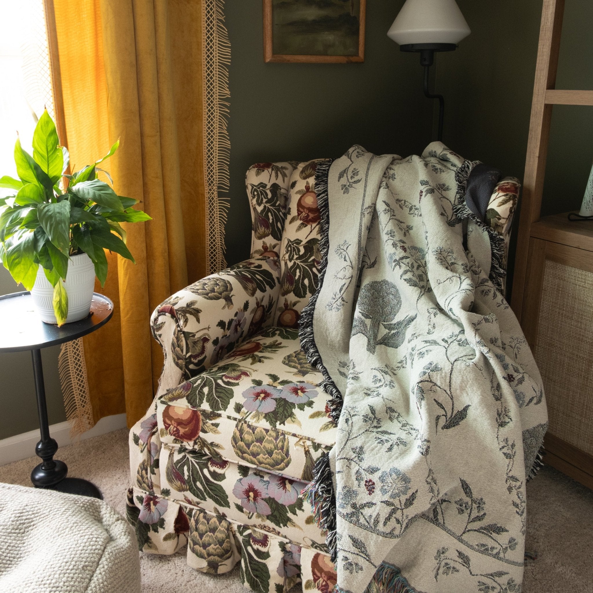 Artichoke woven blanket draped over a floral armchair in a cozy living room setting.