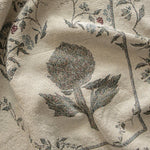 Artichoke woven blanket featuring a floral design with artichoke and vine motifs in muted colors on a light background.