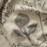 Artichoke woven blanket featuring a floral design with artichoke and vine motifs in muted colors on a light background.