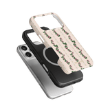 Blackberry iPhone case featuring a floral design on a cream background, layered over black and silver cases.
