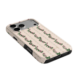 Blackberry iPhone case featuring a floral design with roses on a light pink background, angled to show side and back.