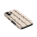 Blackberry iPhone case featuring a floral pattern with pink roses on a cream background, angled view showing buttons and p...