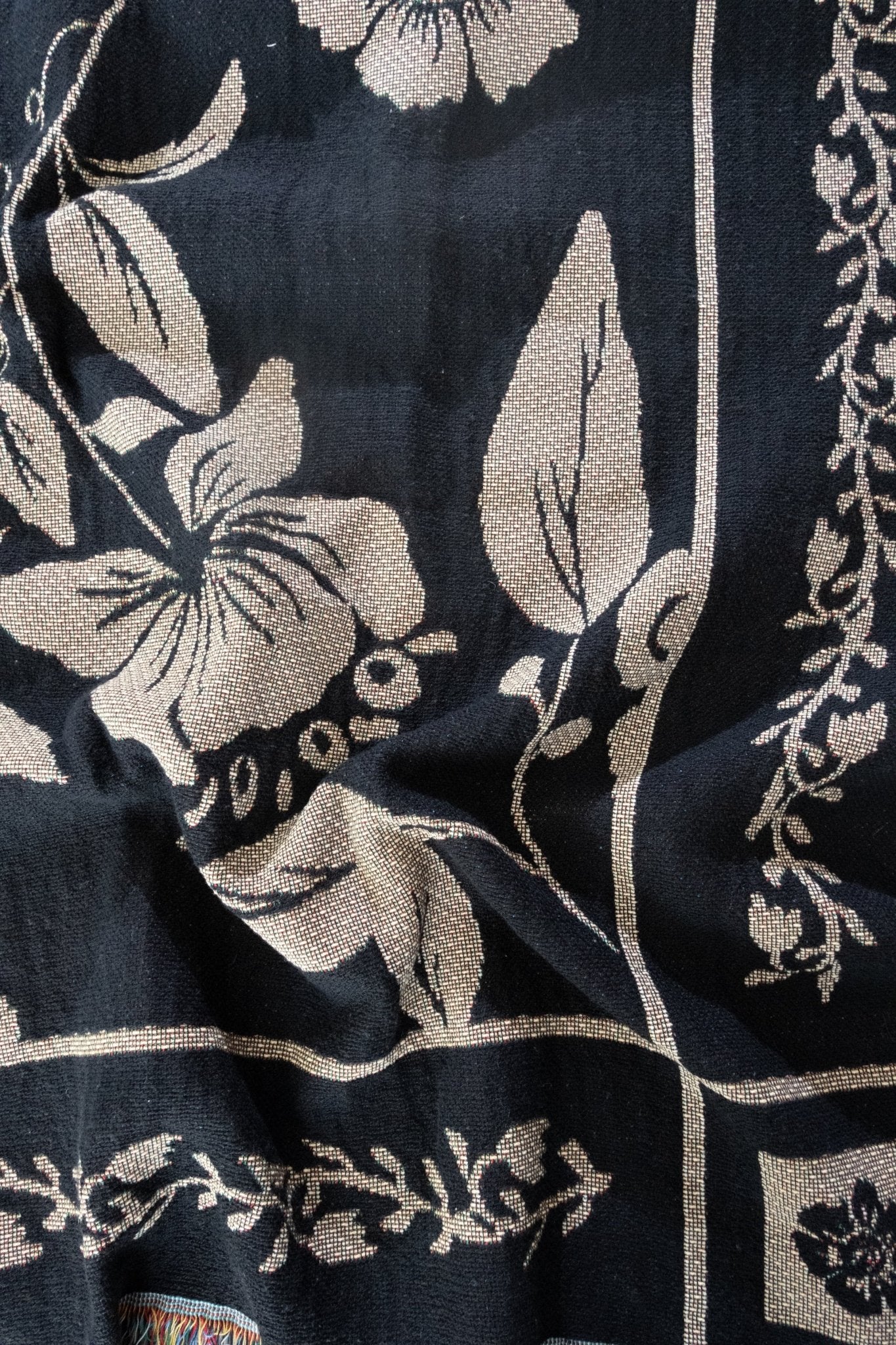 Bramble woven blanket featuring a floral design in cream on a dark navy background.