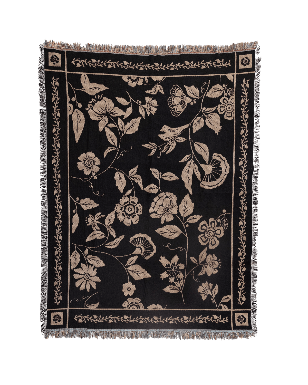 Bramble woven blanket featuring a floral design in cream on a black background with fringed edges.