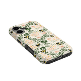 Bumblebee iPhone case featuring a floral design with bees on a cream background, angled view showing camera cutout.