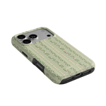 Camellia iPhone case featuring a floral pattern on a light green background, angled view showing camera cutout.