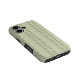 Camellia iPhone case featuring a floral pattern on a light green background, angled to show side and ports.