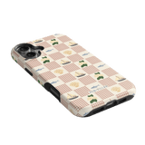 Coastal iPhone case featuring a checkered pattern with boats, trees, and sailboats in soft colors on a light background.