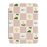 Coastal Kindle case featuring a patchwork design with boats, fish, shells, and floral patterns on a cream background.