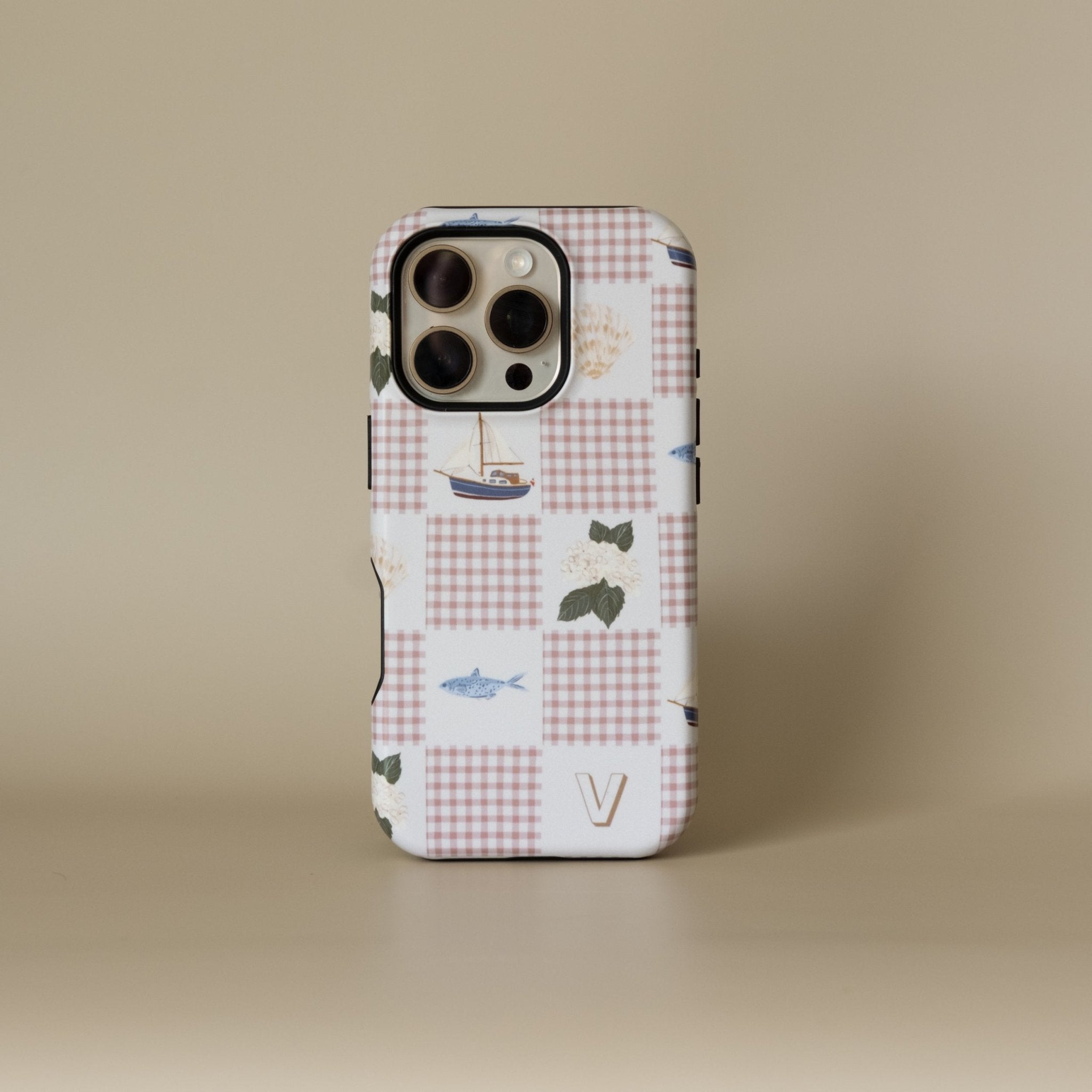 Coastal personalized iPhone case featuring a patchwork design with boats, fish, and floral elements in soft colors.