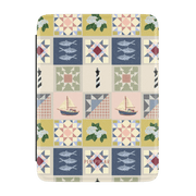Rectangular Kindle case with a quilt pattern featuring lighthouses, sailboats, fish, and flowers. PEN + PILLAR printed on ...