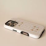 Cora personalized iPhone case featuring a floral design with gold accents on a white background.