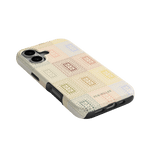 Curio iPhone case featuring a textured design with colorful squares on a cream background, angled view.