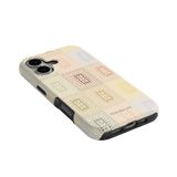 Curio iPhone case featuring a textured design with colorful squares on a cream background, angled view.
