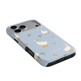 Ducks iPhone case featuring a light blue background with white ducks and floral accents, angled view showing ports.