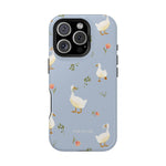 Ducks iPhone case featuring a light blue background with white ducks and pink flowers.