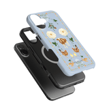 Farmland iPhone case featuring a light blue background with floral and animal designs, stacked with a black case.