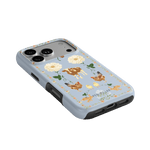 Farmland iPhone case featuring floral and animal designs on a light blue background with a black border.