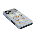 Farmland iPhone case featuring a light blue background with floral and animal illustrations, including cows and chickens.