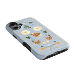 Farmland iPhone case featuring a light blue background with floral and animal illustrations, including cows and chickens.