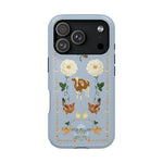 Farmland iPhone case featuring a blue background with floral designs, cows, chickens, and decorative elements.