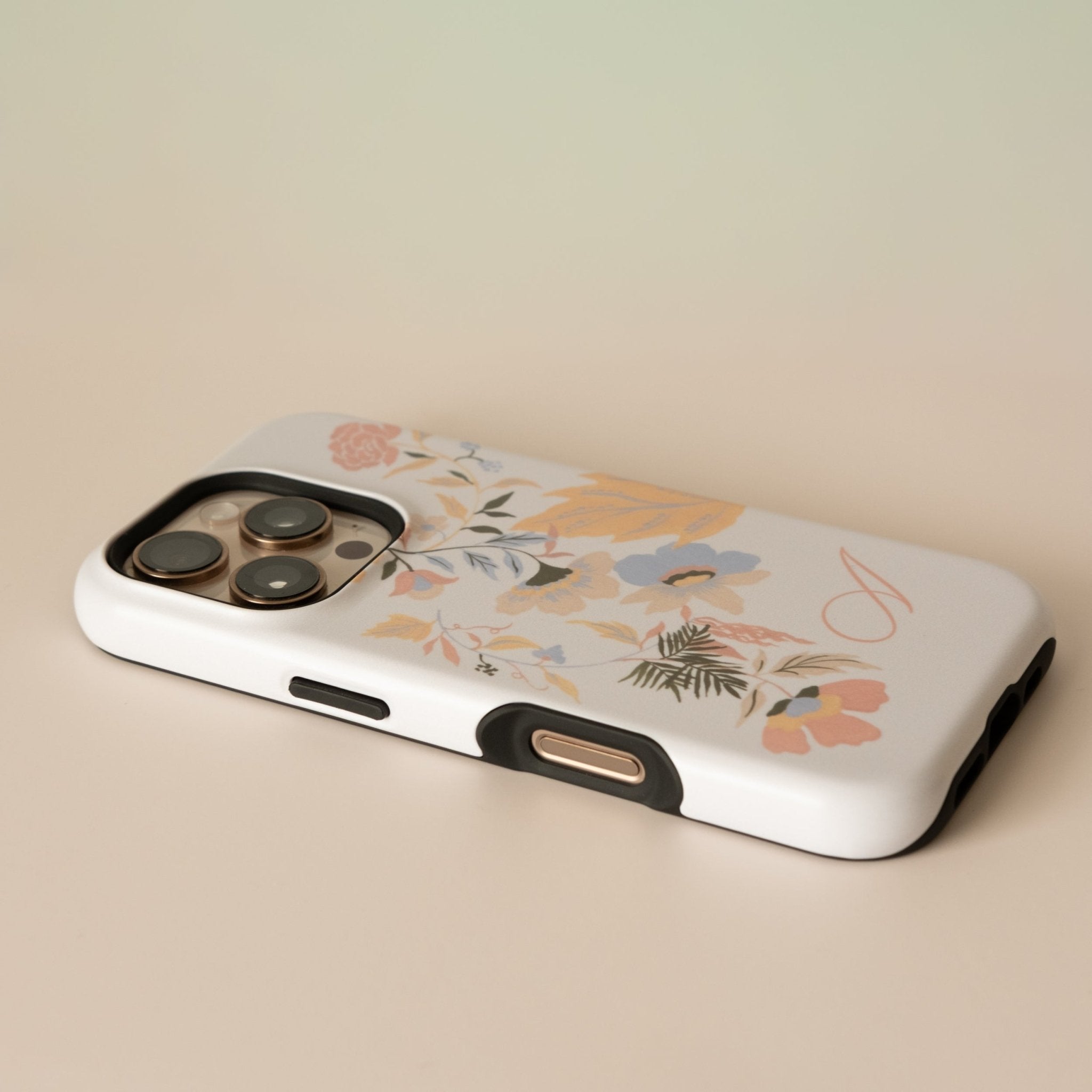 Fleur personalized iPhone case with floral design in pastel colors, angled view showing camera cutout and buttons.
