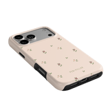 Forage iPhone case in soft pink with small floral patterns and black edges, angled to show camera cutout.