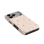 Forage iPhone case in light pink with floral patterns and black edges, showcasing camera cutouts and ports.