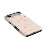 Forage iPhone case featuring a light pink background with small floral patterns and black edges.