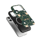 Forest iPhone case featuring a floral design with deer, layered over black and silver cases on a green background.