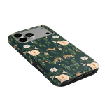 Forest iPhone case featuring floral and deer patterns on a dark green background, angled to show the camera cutout.
