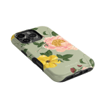 Garden Rose iPhone case featuring pink and yellow floral designs on a light green background, angled view.